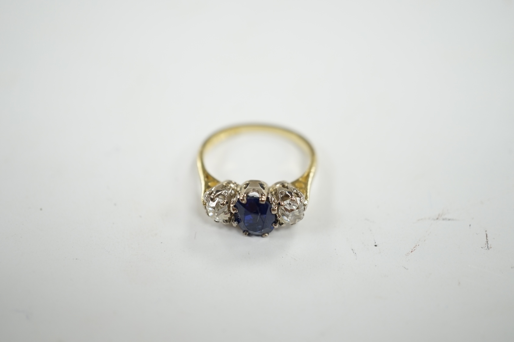 A late 1970's 18ct gold, sapphire and diamond set three stone ring, size J/K, gross weight 3.8 grams. Condition - fair